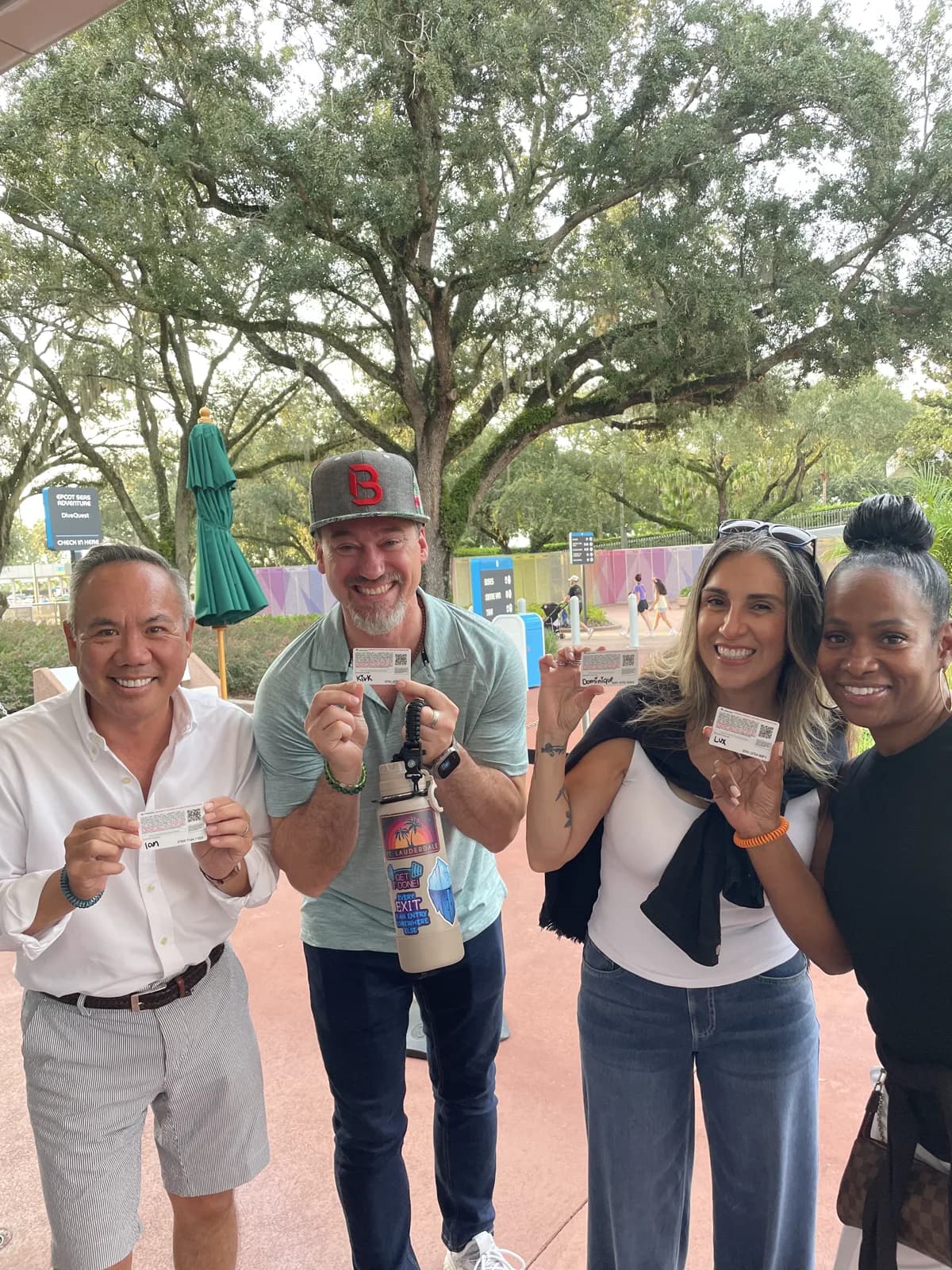 Dr. Michael Njo with three fellow Backstage Mastermind members holding tickets outside at Disney World