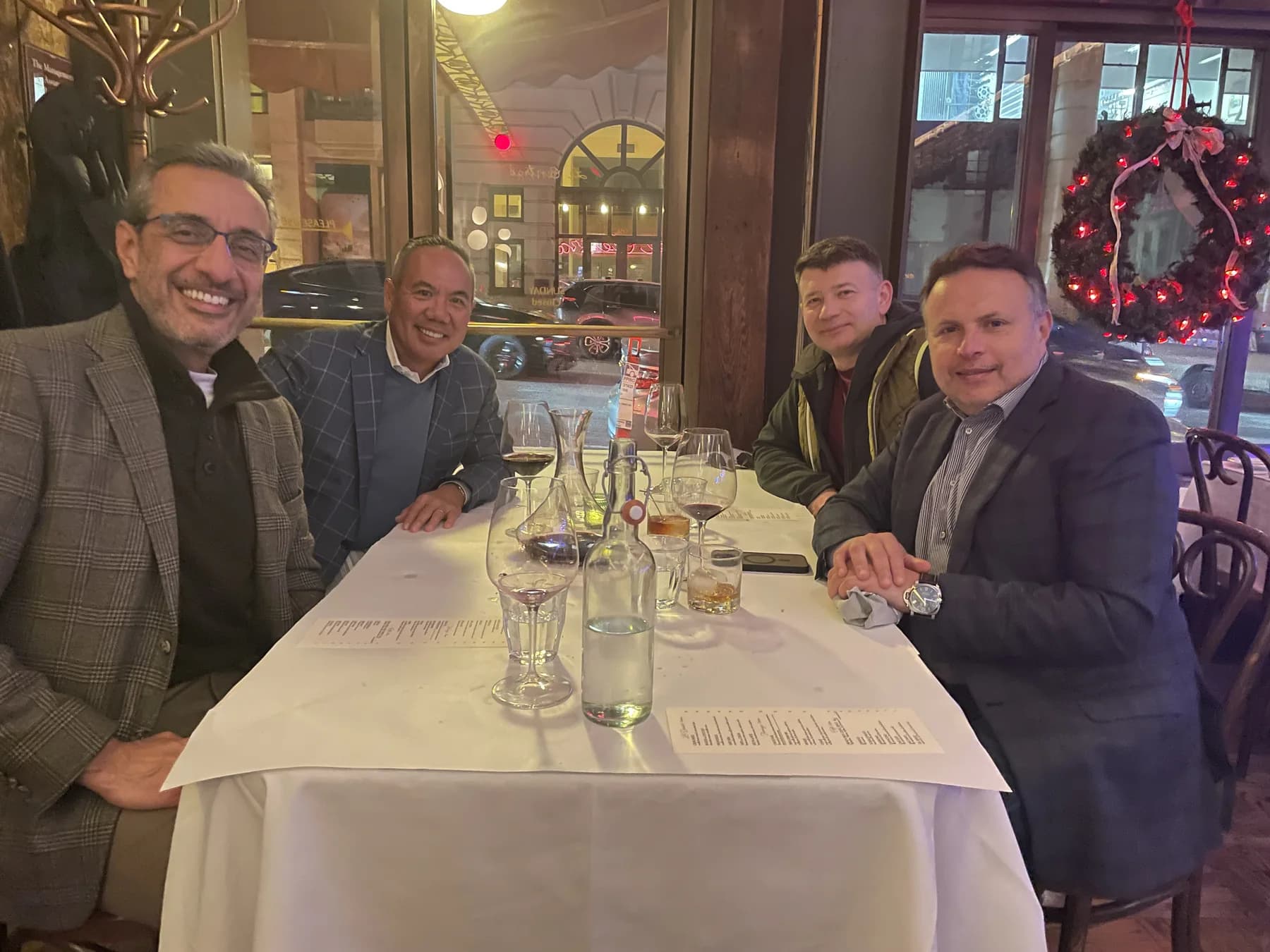 Dr. Michael Njo dining with three colleagues at a restaurant table