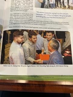 Publication spread showing Dr. Michael Njo speaking with younger dental professionals at a networking event