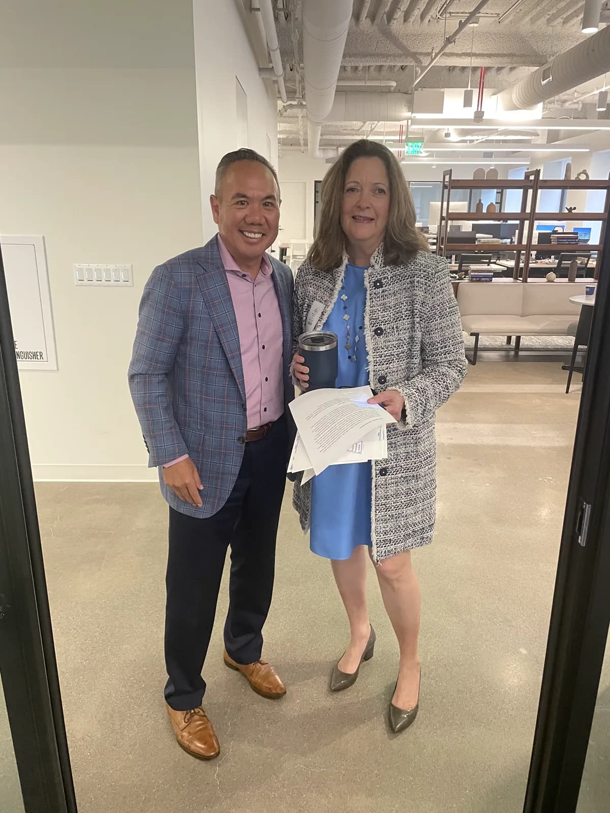 Dr. Michael Njo standing with a colleague holding seminar materials at the July 2026 San Francisco seminar venue