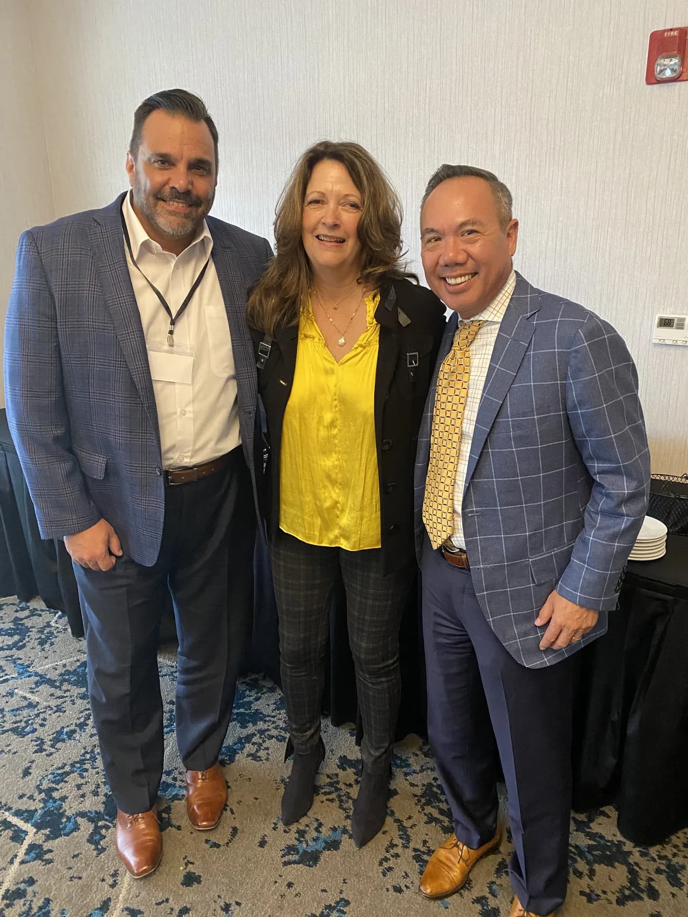 Dr. Michael Njo standing with two dental industry colleagues at a professional event