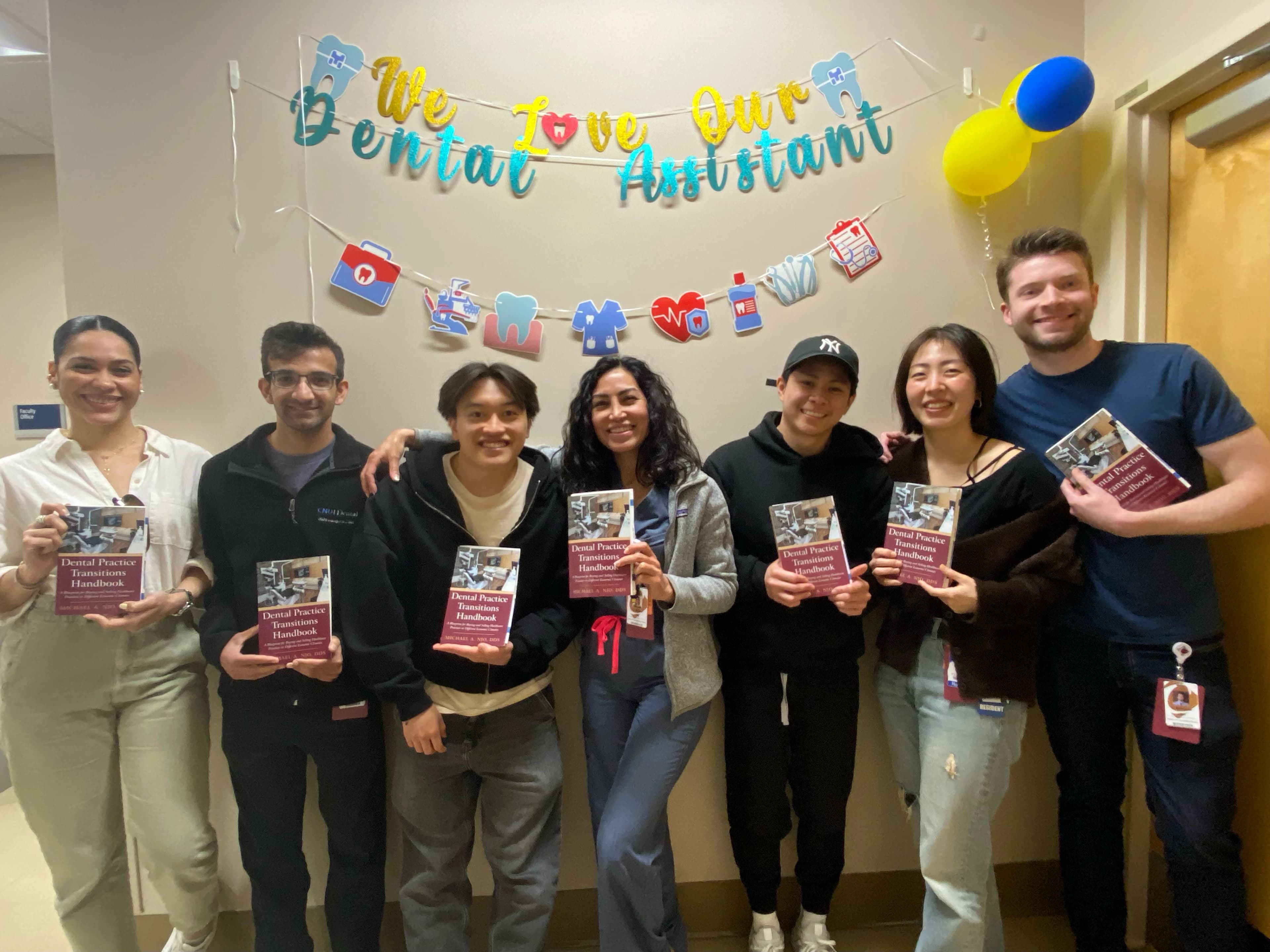 Michael Njo, DDS presenting to General Practice Residency residents holding the Dental Practice Transitions Handbook he wrote