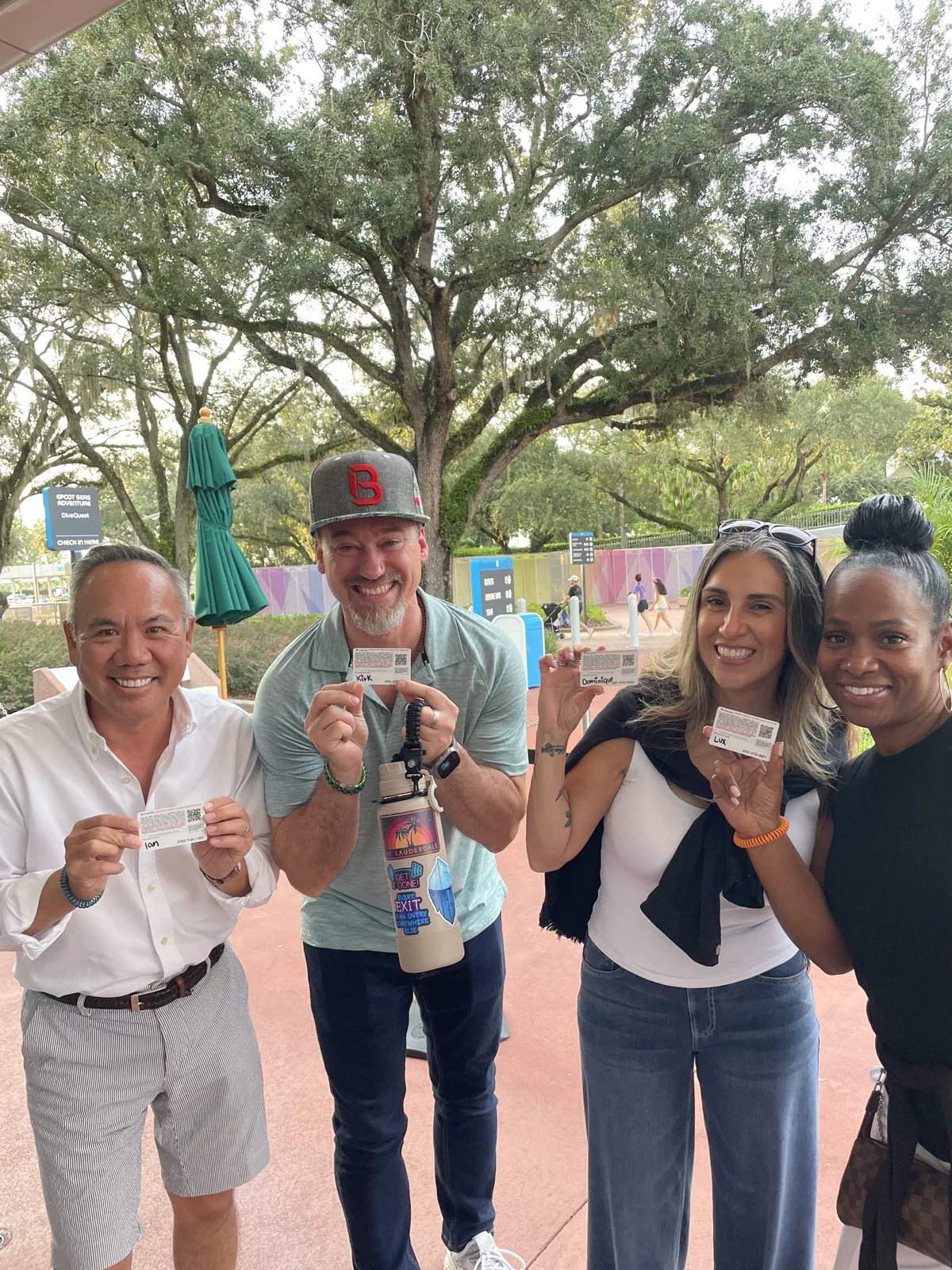 Dr. Michael Njo with three fellow Backstage Mastermind members holding tickets outside at Disney World