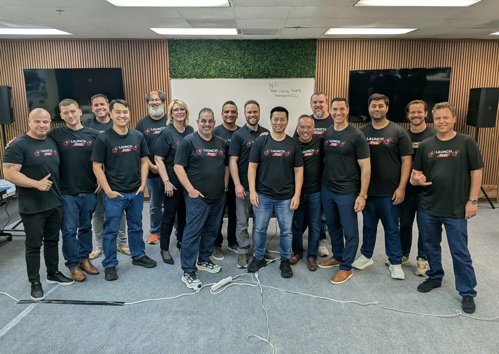 Dr. Michael Njo with fellow Backstage Mastermind members in matching Launch Pod shirts at the Dallas retreat