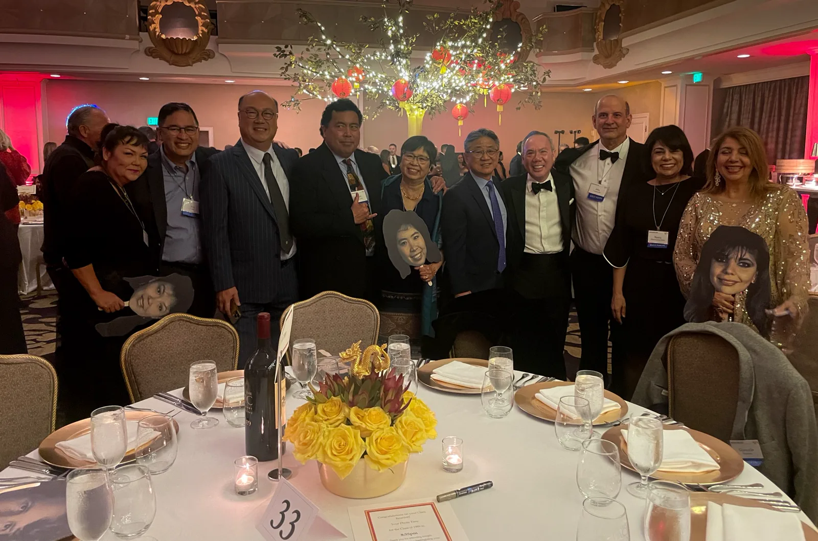 Dr. Michael Njo with Pacific Dugoni alumni colleagues and classmates in formal attire gathered around a table at an Alumni Association evening