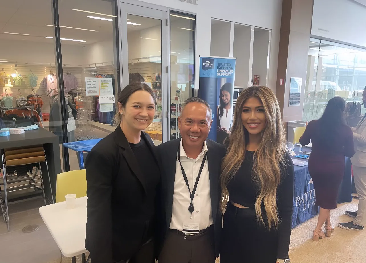 Dr. Michael Njo with two industry sponsor representatives at the Dugoni Business Club Symposium vendor fair